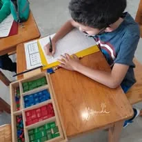 Alumno trabajando con material Montessori